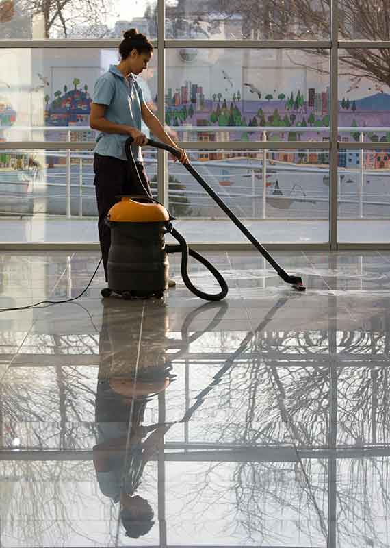 Lady cleaning commercial floor with special machine